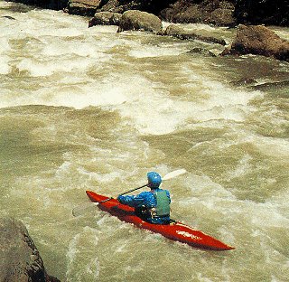 Kayaker in churning waters of a Costa Rican river.