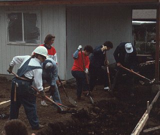 Volunteers dig in to raise a house.