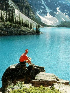 A hiker pauses to enjoy azure Moraine Lake.