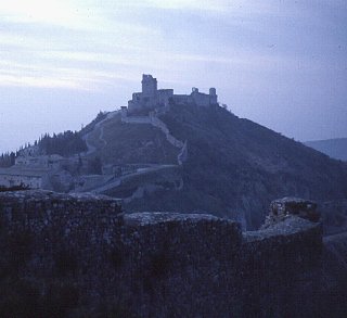 A walled city perches atop a Tuscan hill.