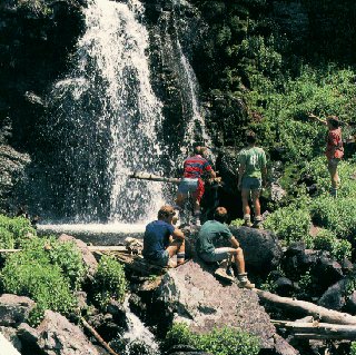 Campers explore a Rocky Mountain waterfall.