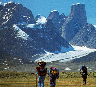 Hikers head toward jagged peaks.