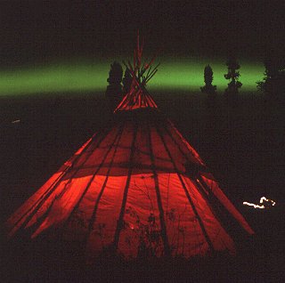 A tepee with the aurora borealis behind.